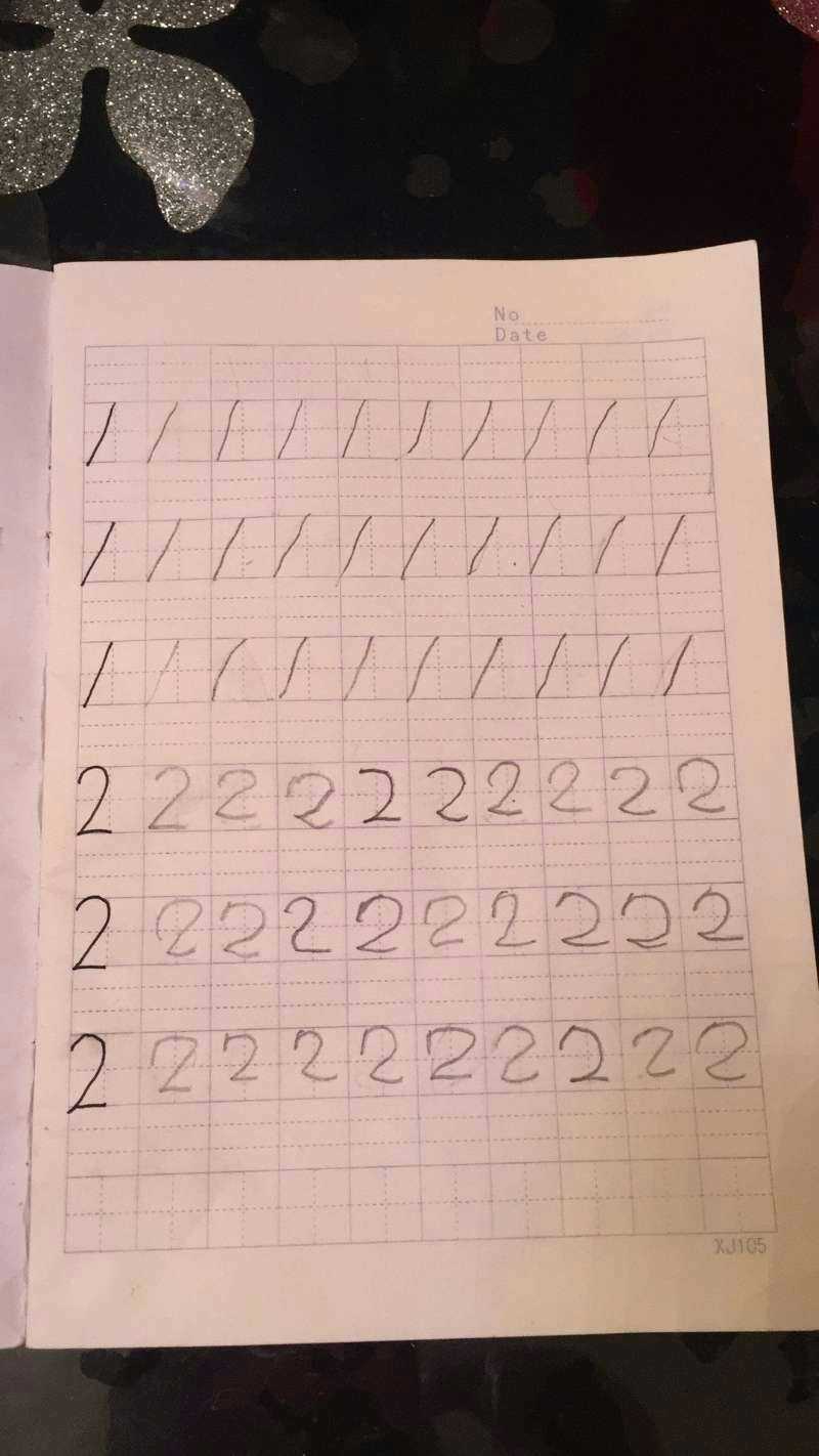 幼儿园开始教写字,今天女儿回家后兴致勃勃的写"1"和"2,还说