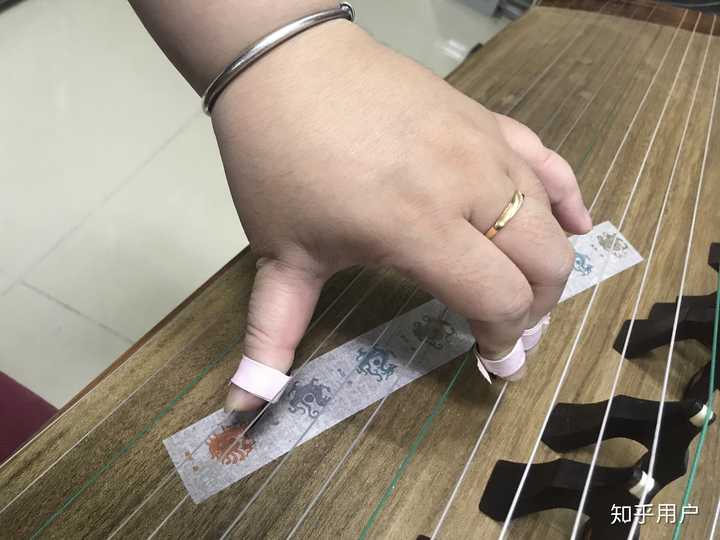 古筝左手按弦是用手指尖按,还是用手指与假指甲之间的缝隙按?