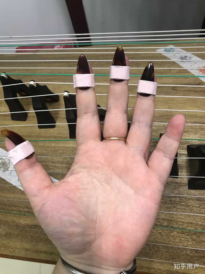 古筝左手按弦是用手指尖按,还是用手指与假指甲之间的缝隙按?