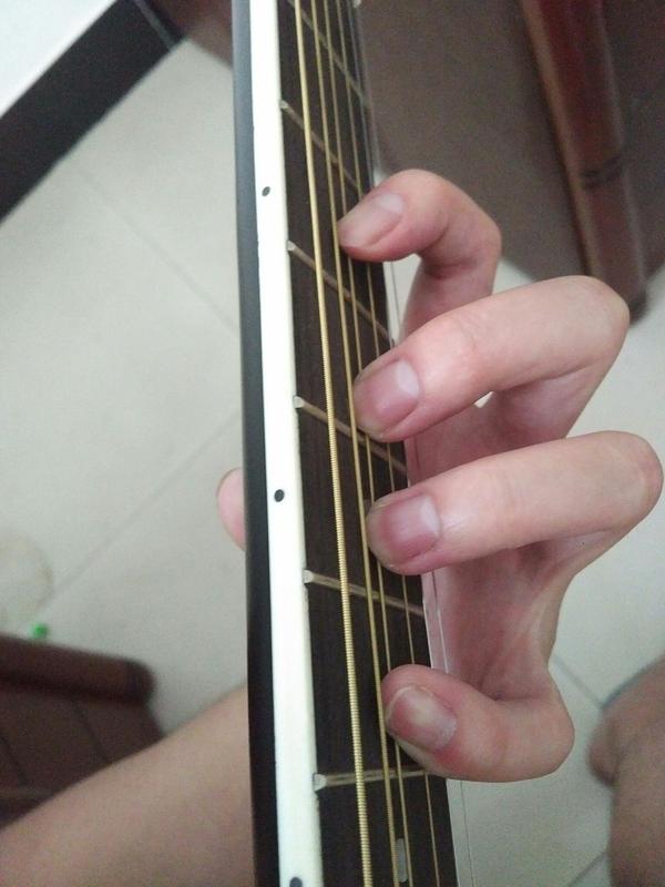 吉他左手小拇指指尖往无名指上靠,按弦的时候没法垂直