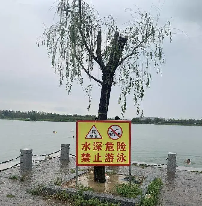 而"水深危险,禁止游泳"的告示牌就贴在岸边!