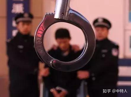 图为潜逃8年的杀人犯铐上手铐抓捕归案