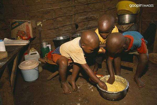 难民儿童吃玉米粥 .