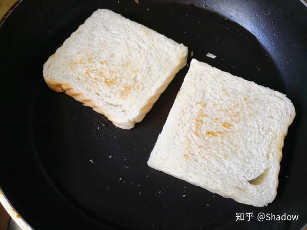 平底锅中放入少许油,用小火将吐司煎至两面微黄出锅备用