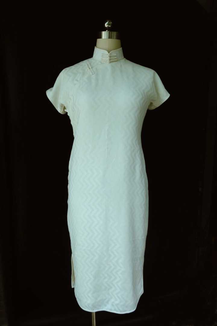 这是一件40年代的衣身轮廓搭配30年代领子的旗袍,长度过膝一掌,侧面低