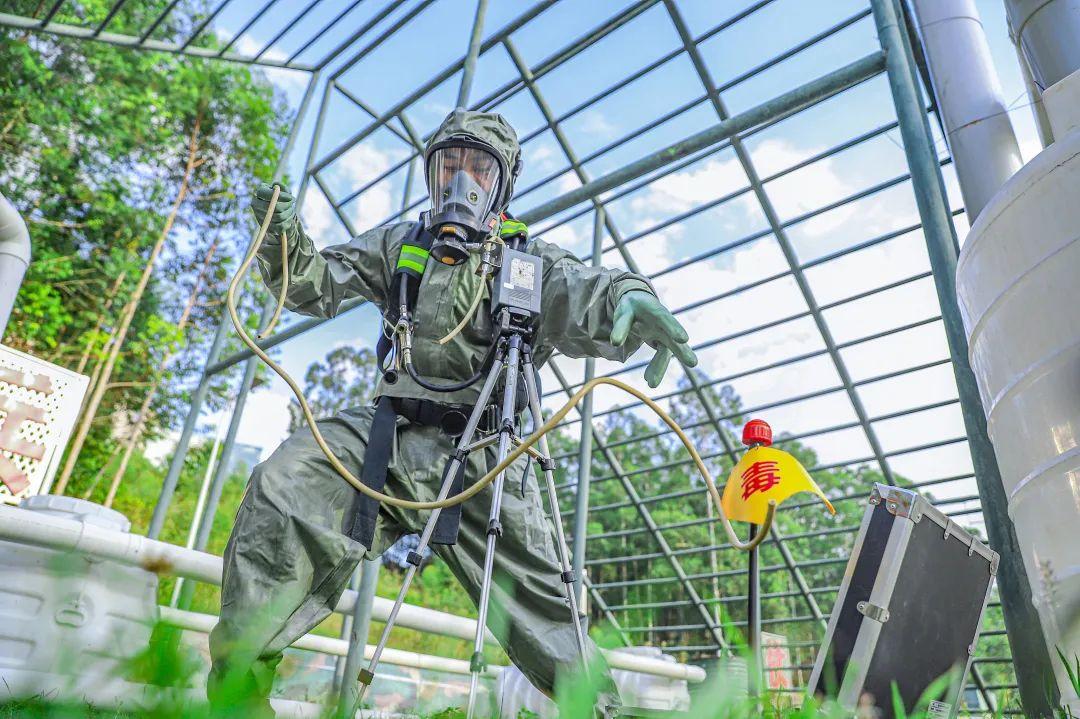 防化分队官兵相互整理防护服.