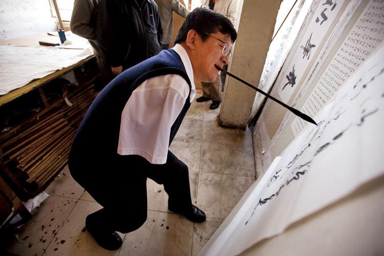 他没有双臂,用嘴咬着毛笔写字.和志刚是非常有名的书法家.