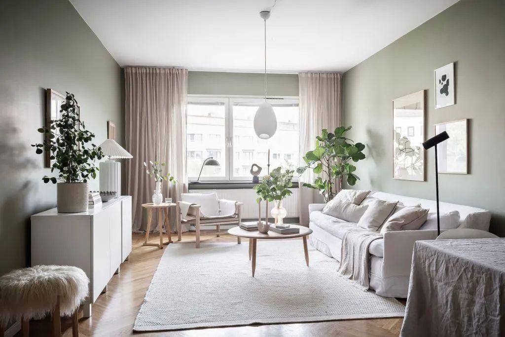 这间瑞典公寓中柔和的灰绿色墙面将室内装饰提升到了另一个层次.