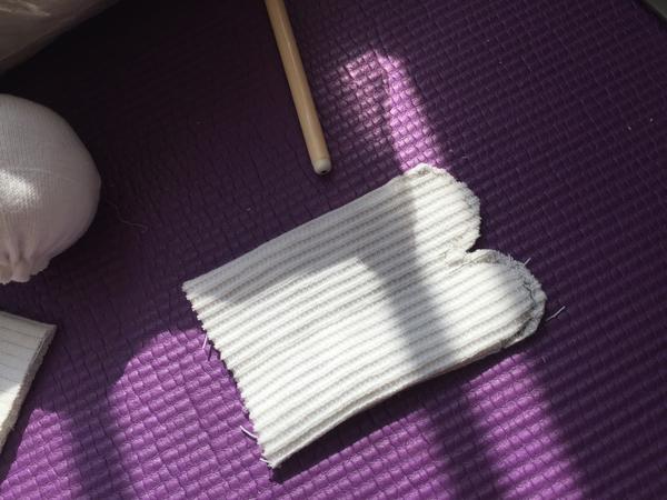 取一截白袜子,翻到反面,画出并剪出两条腿的形状,用回针法缝合.