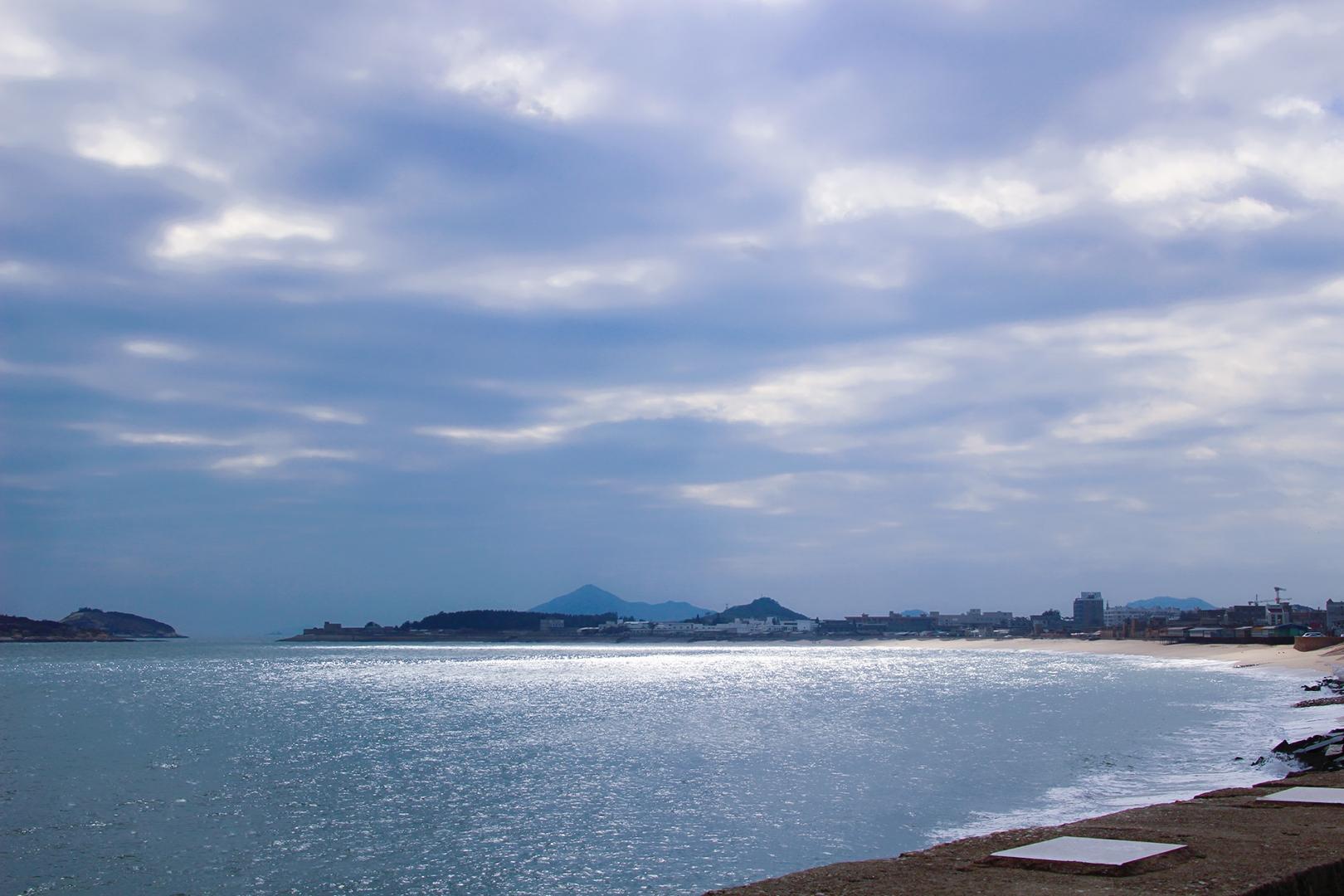 海堤旁边的房子,有一部分房子的外墙漆上了各种颜色,在阳光照耀下色彩