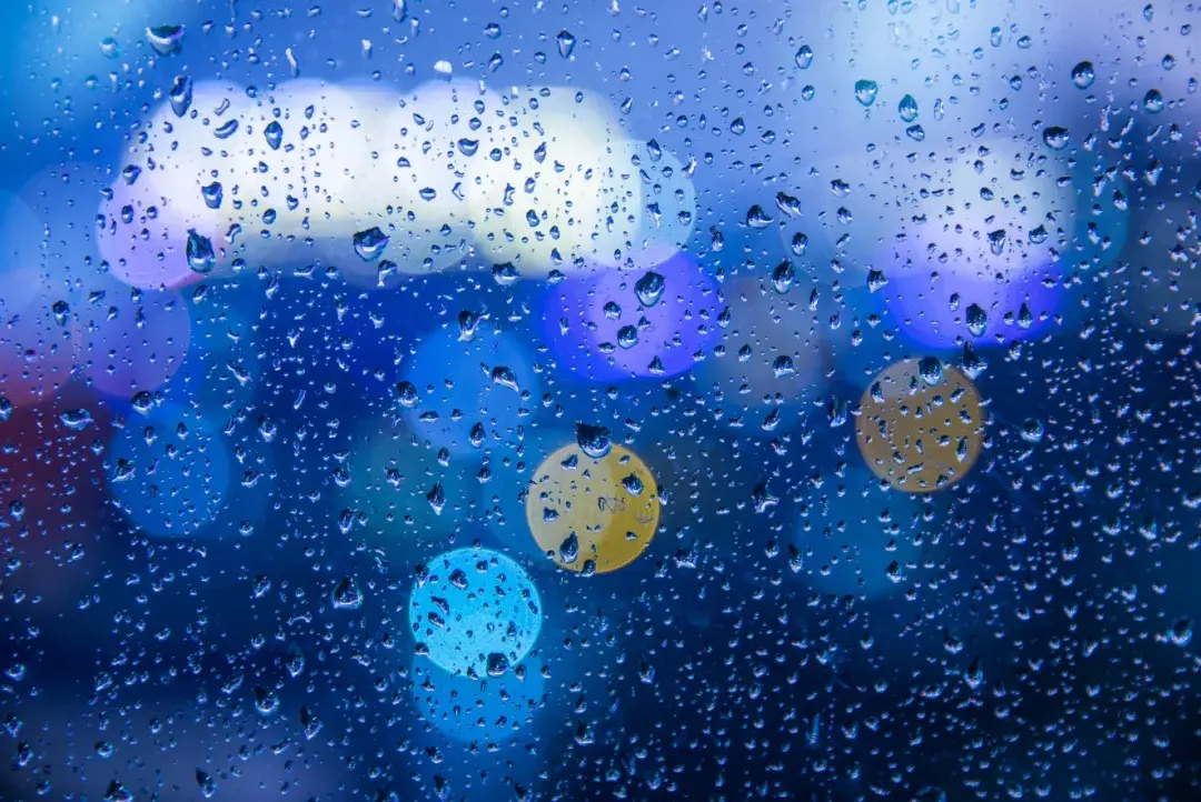 点击手机对焦圈,将焦点对在车窗玻璃的雨珠上,虚化背景中的灯光,使其