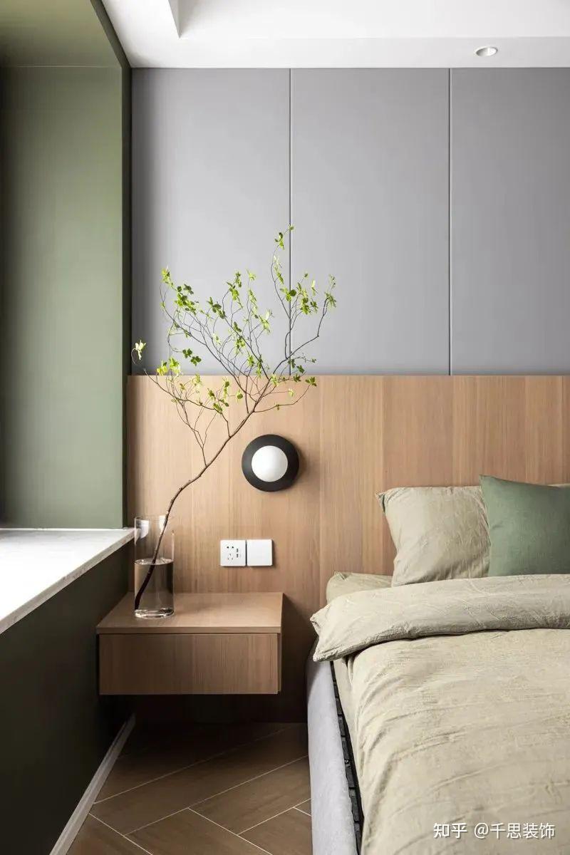床头背景墙一分为二,上部分灰色硬包,下部分用木饰面造型搭配线性灯带