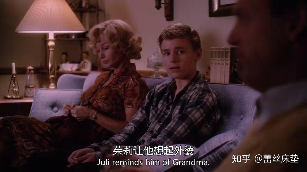 阳光透过方格玻璃窗洒下来,打在室内白墙与木制家具上,坐在窗前的沙发