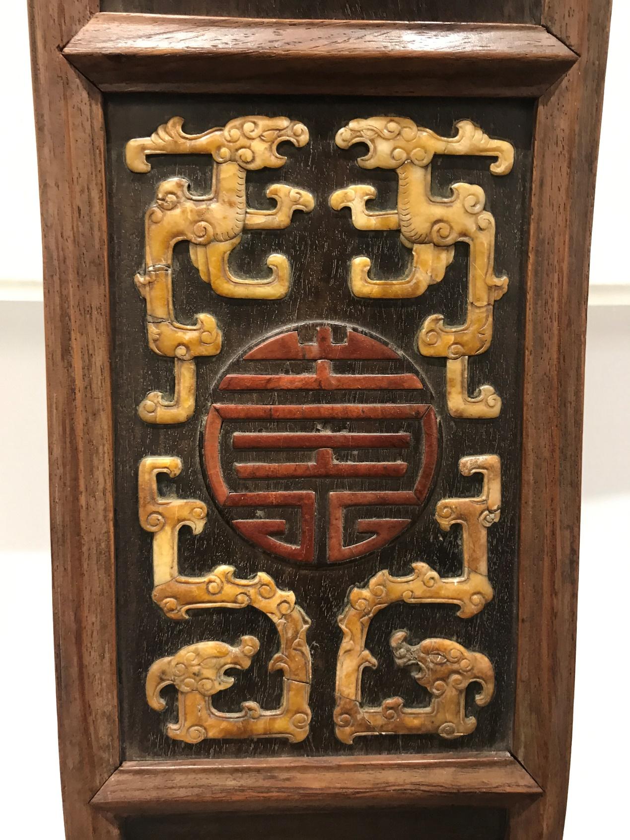 中段落膛装板,中间鼓出圆凸,红石拼寿字纹,四角嵌黄石拐子龙图案,如