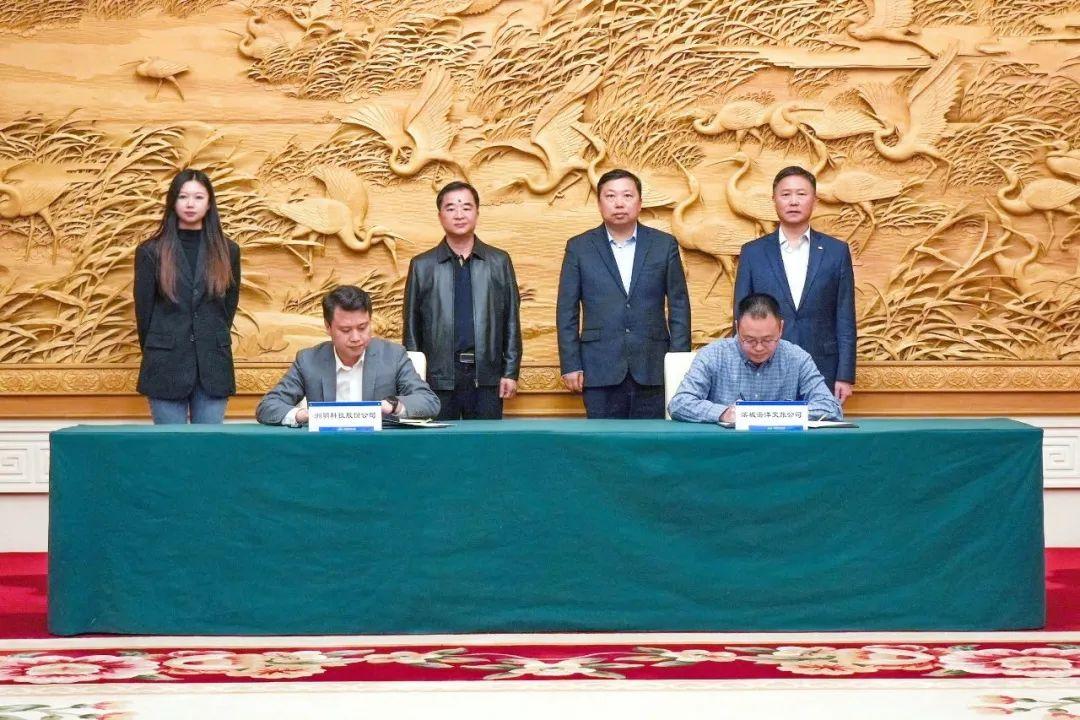 刘建亮(前左)与刘平(前右)作为各方代表签约.